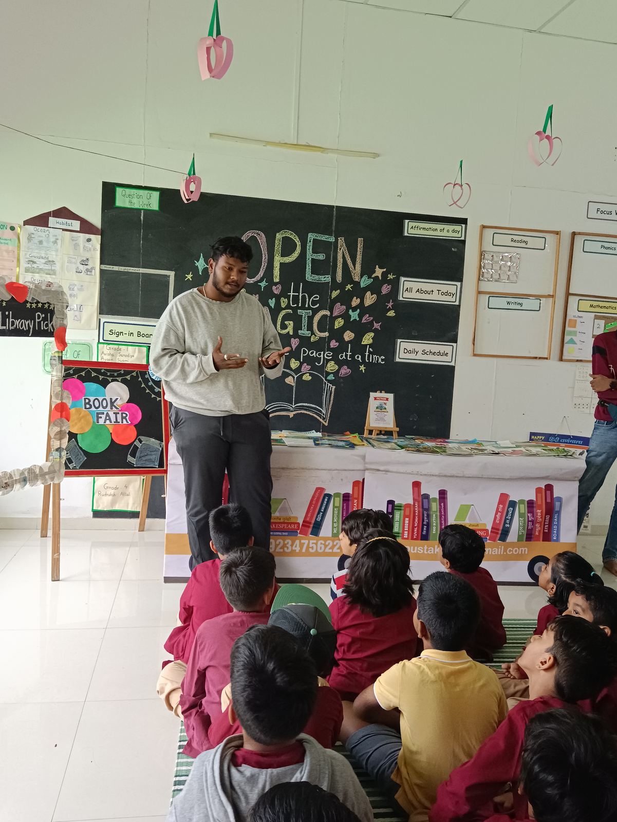 A teacher reads to children seated on the floor